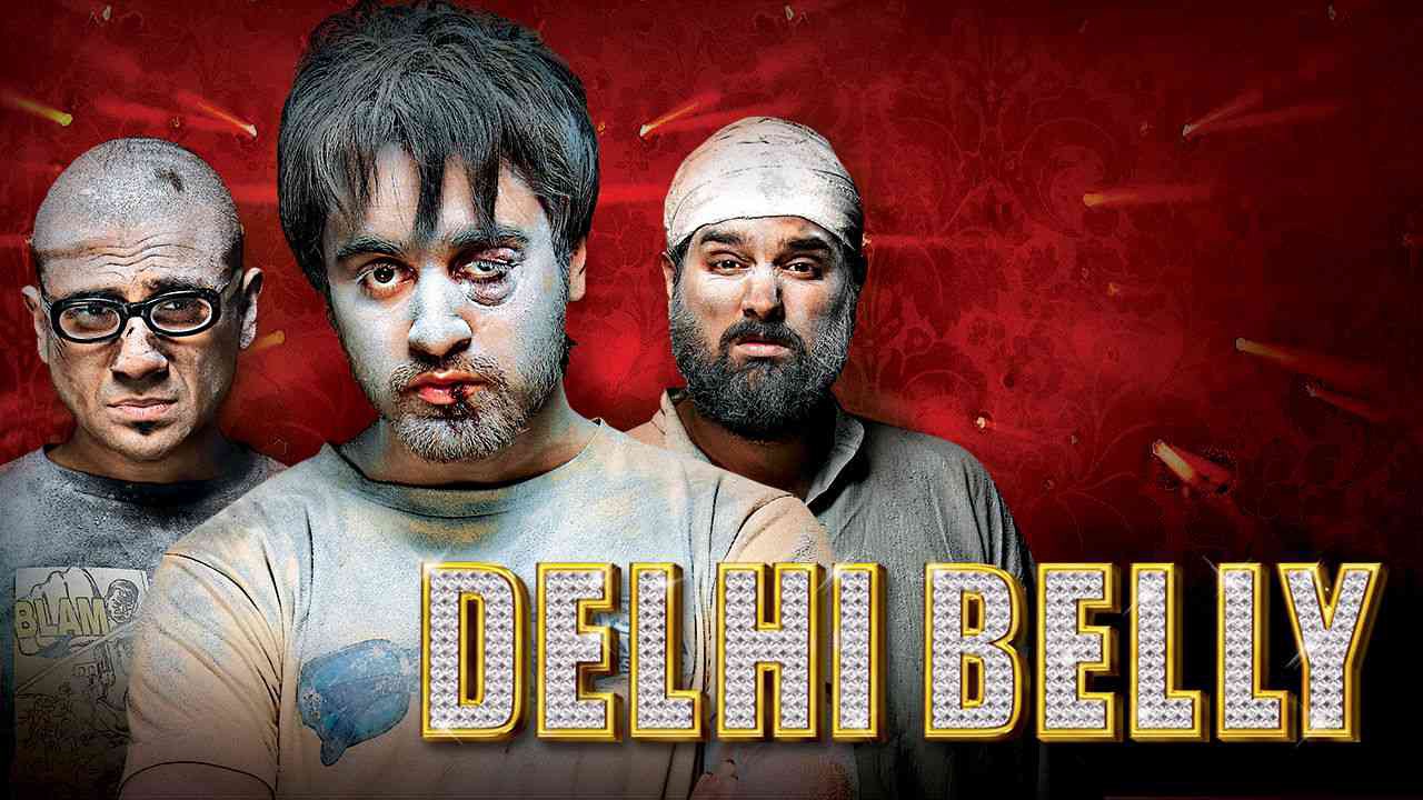 A poster for Delhi Belly. The three leads appear beaten up and covered in dust. The man in the center has a black eye and a split lip.