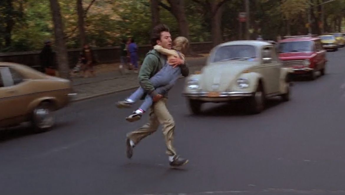 Ted Kramer runs through traffic, carrying his son