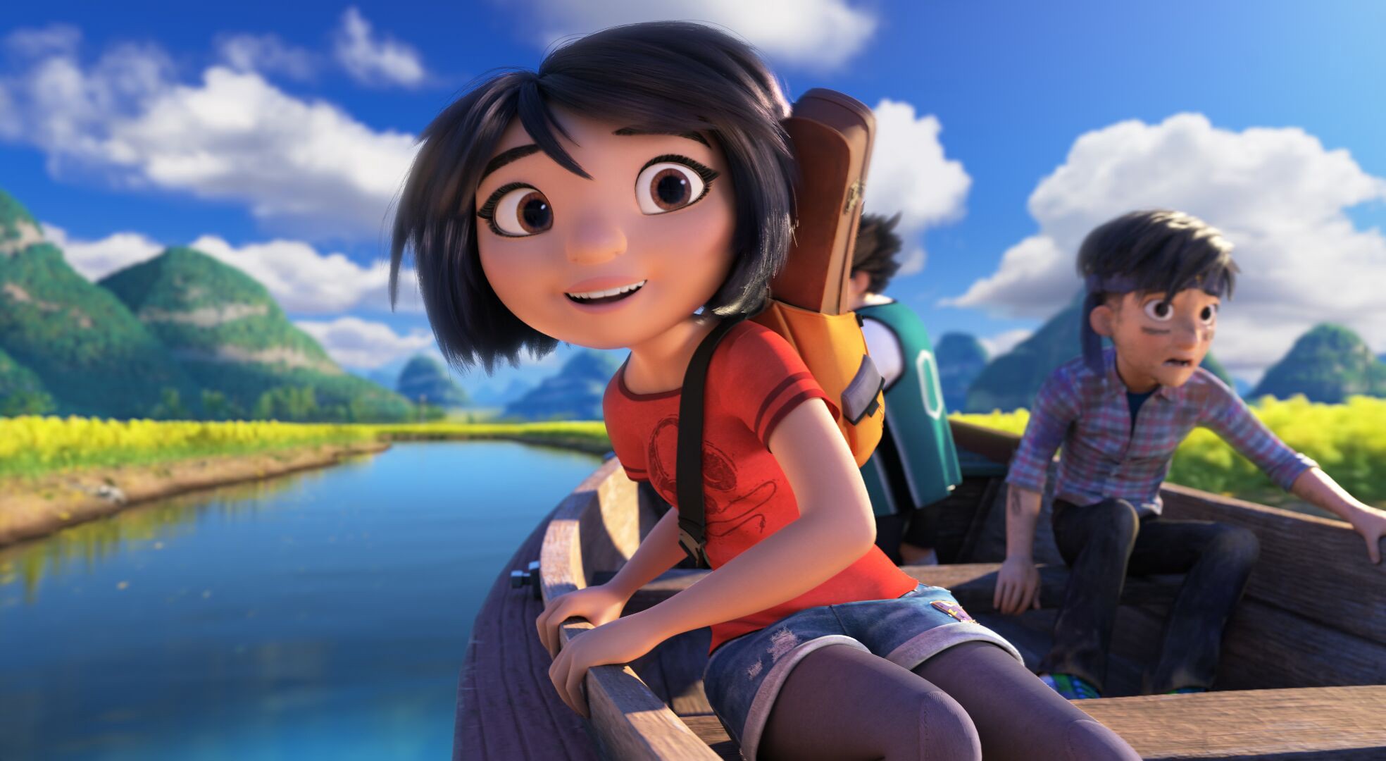 Yi, Peng, and Jin sail down a river in Tibet. Behind, them, a blue sky and fluffy clouds over mountains can be seen. Yi has an excited smile on her face and Jin looks frightened.