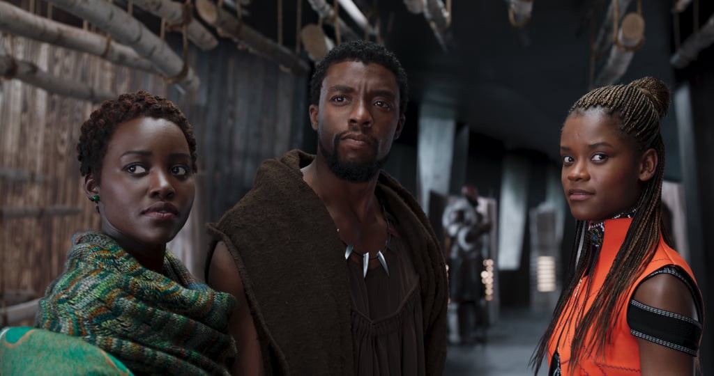 Nakia (Lupita Nyong'o), T'Challa (Chadwick Boseman), and Shuri (Letitia Wright) stand in a corridor.