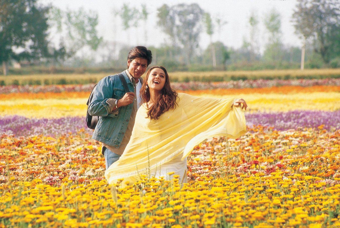 Veer (Shah Rukh Khan) and Zaara (Preity Zinta) stand in a field of yellow and pink flowers