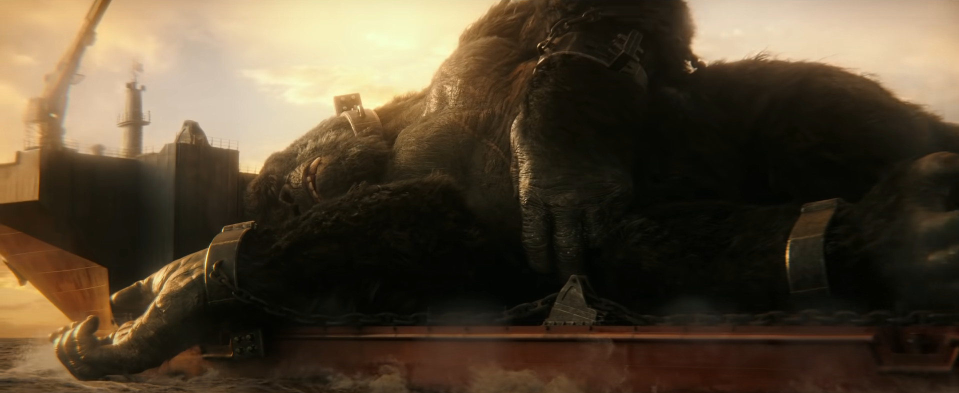 King Kong sleeps on the back of an aircraft carrier, held down by manacles.