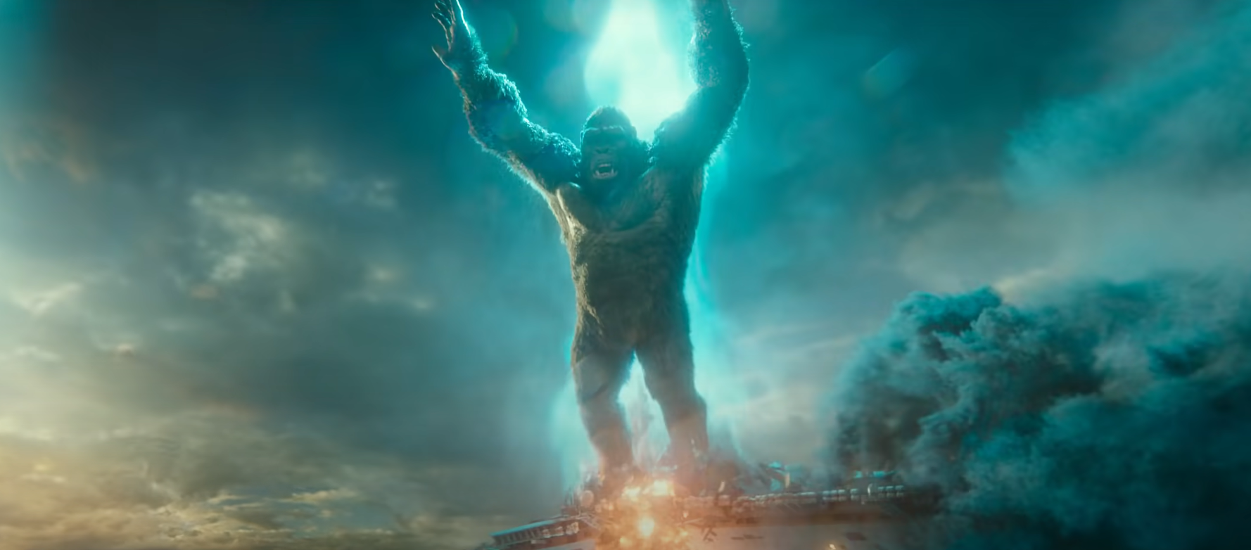 Kong leaps from a ship, backlit by Godzilla's atomic breath.