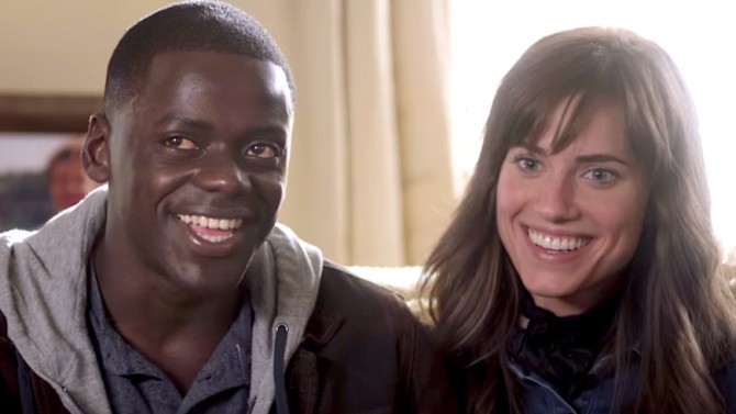 Chris and Rose (Daniel Kaluuya and Allison Williams) sit close together on a couch, smiling.