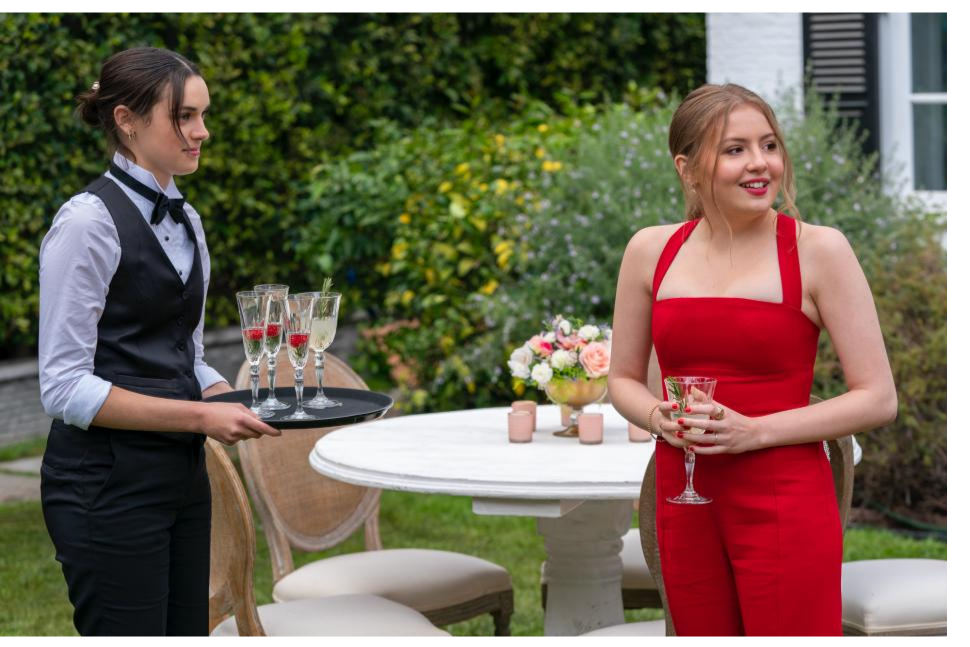 A still of Lake and Lucy standing together at Mia's dad's wedding