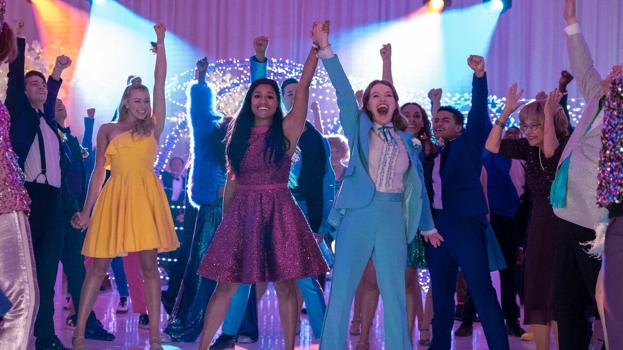 Emma and her girlfriend Alyssa triumphantly raise their joined hands at the prom.