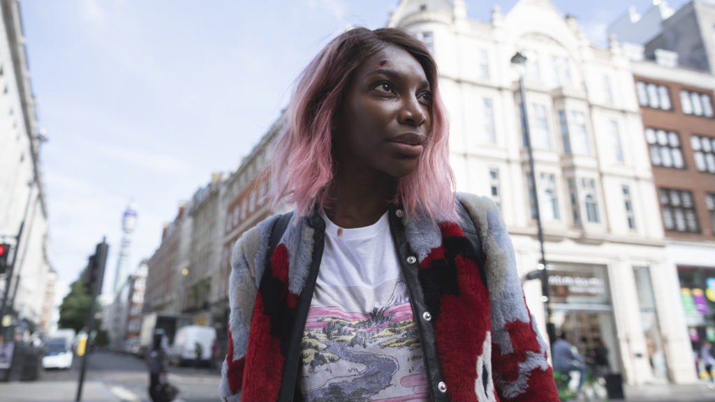 Arabella (Michaela Coel) walks down a city street. She has a small cut on her forehead and a bloodstain on her shirt.