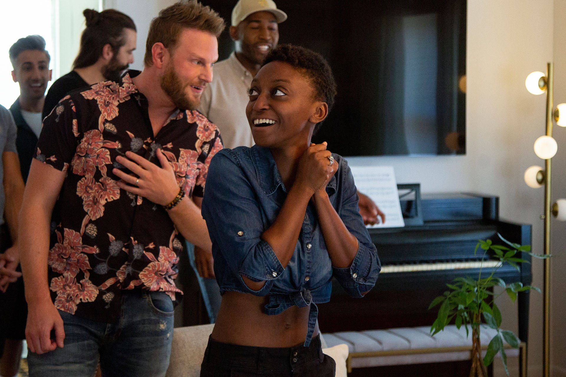 Queer Eye hero Jess reacts with surprise and delight to her remodeled home. The Fab Five follow her into the room.