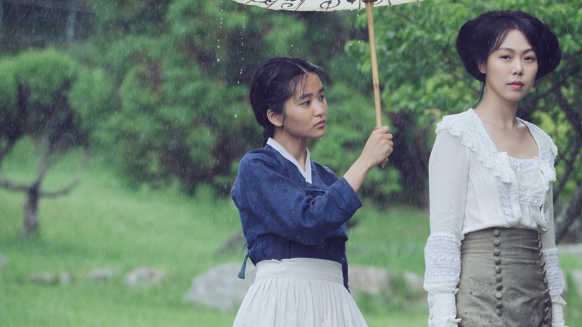 Sook-hee holds a parasol over Izumi's head.