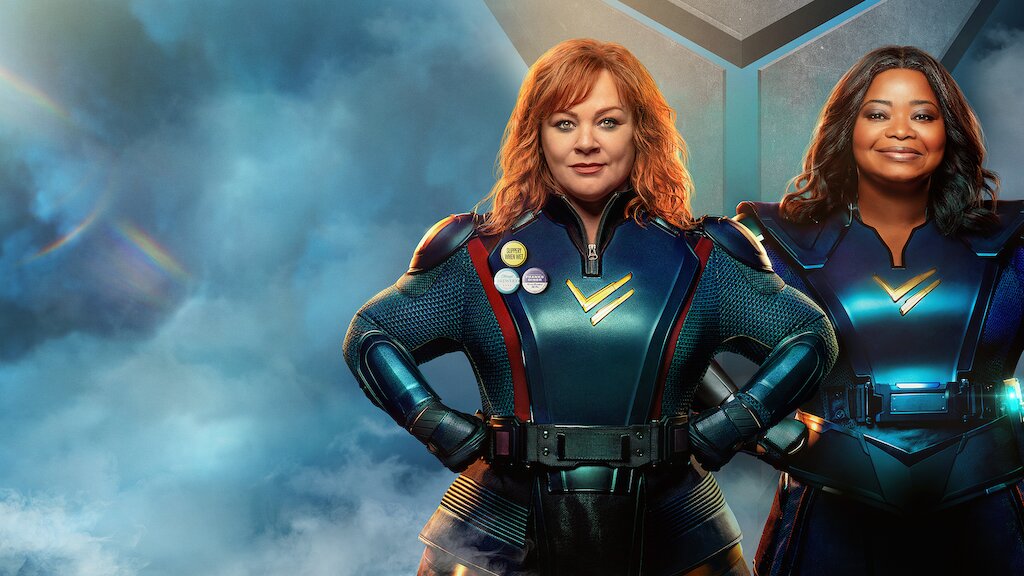 Lydia (Melissa McCarthy) and Emily (Octavia Spencer) stand with their hands on their hips, wearing superhero leotards.