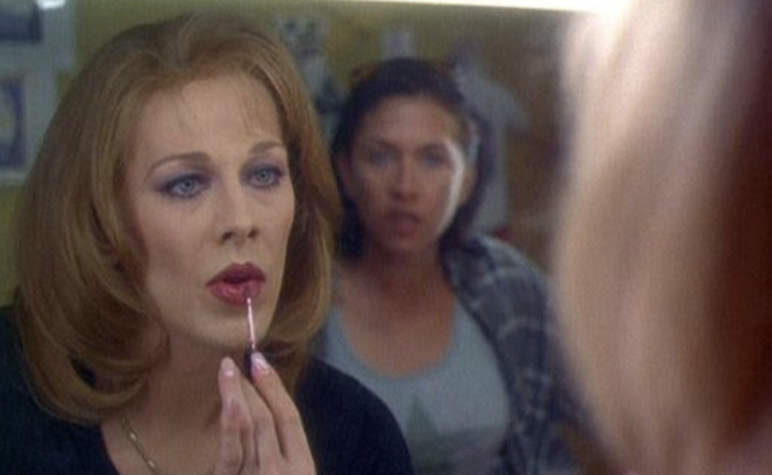 Judy applying lipstick in the mirror as her soon-to-be attacker leers at her.
