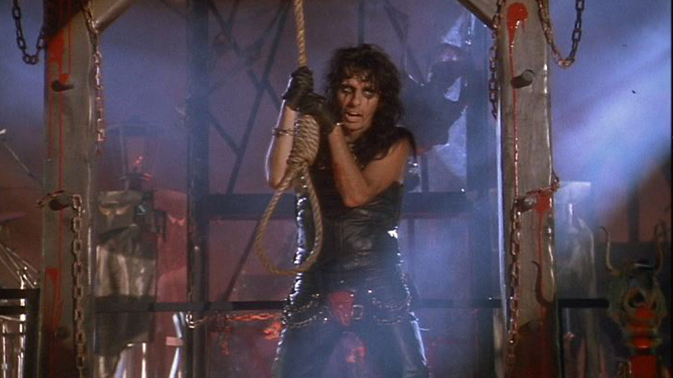 Alice Cooper holding a noose, by a gothic execution set
