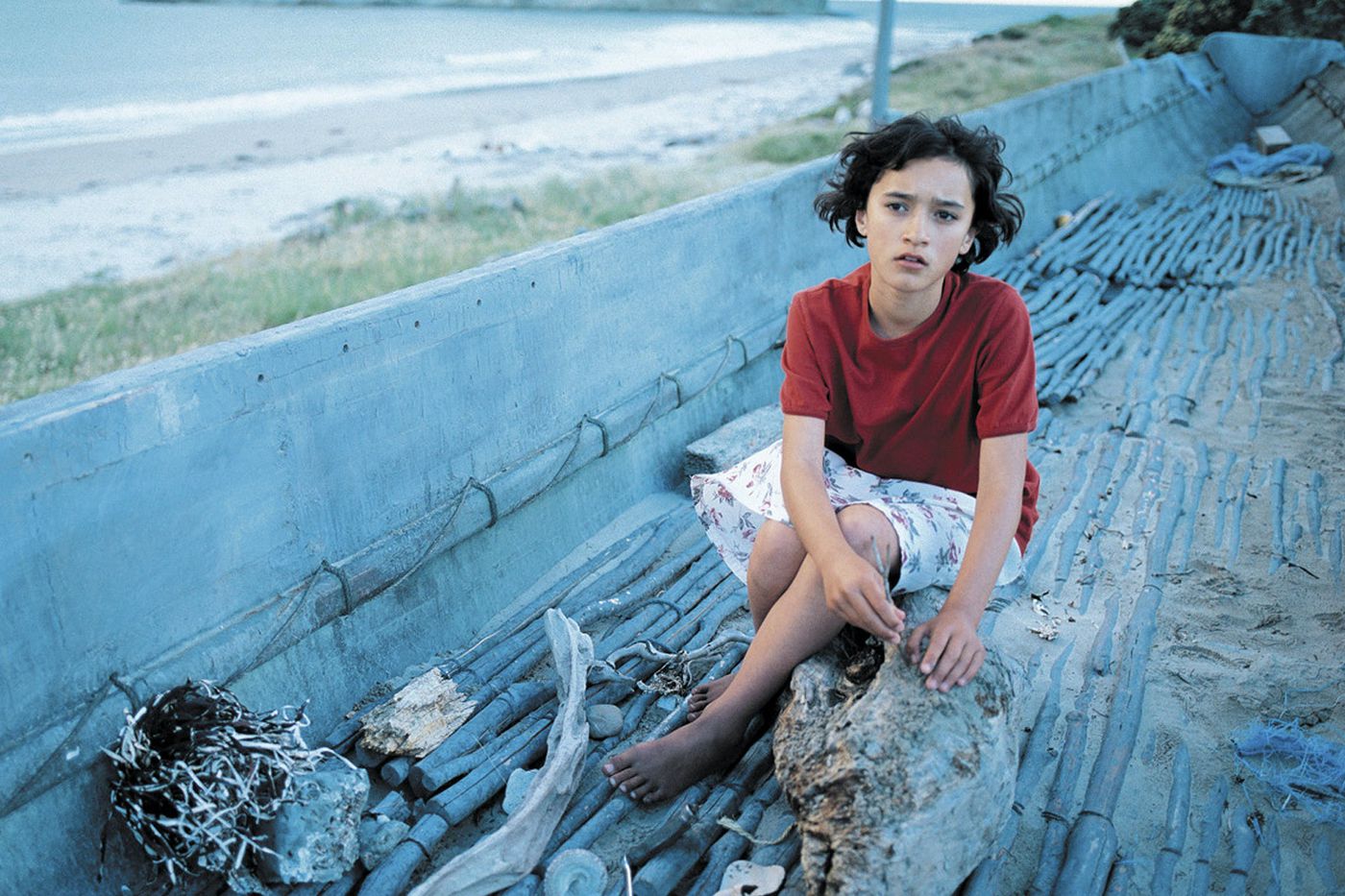 Pai is wearing a red shirt with a short dress, sitting on branches