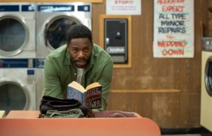 A still from 'Candyman' of Burke reading in the laundromat