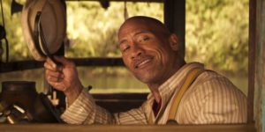 A still from "Jungle Cruise" of Frank smiling and waving his hat