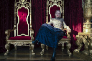 A still from 'Cinderella (2021)' of Princess Gwen lounging on the throne