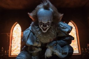 Pennywise stares into the camera, smiling.