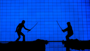 Shadowy figures fighting against a blue background.