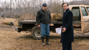 Two men standing outside in front of a truck.