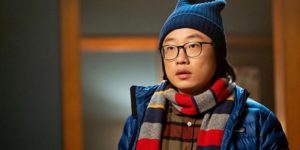 A still from 'Love Hard' of Jimmy O. Yang as Josh, dressed in a scarf, jacket, and beanie