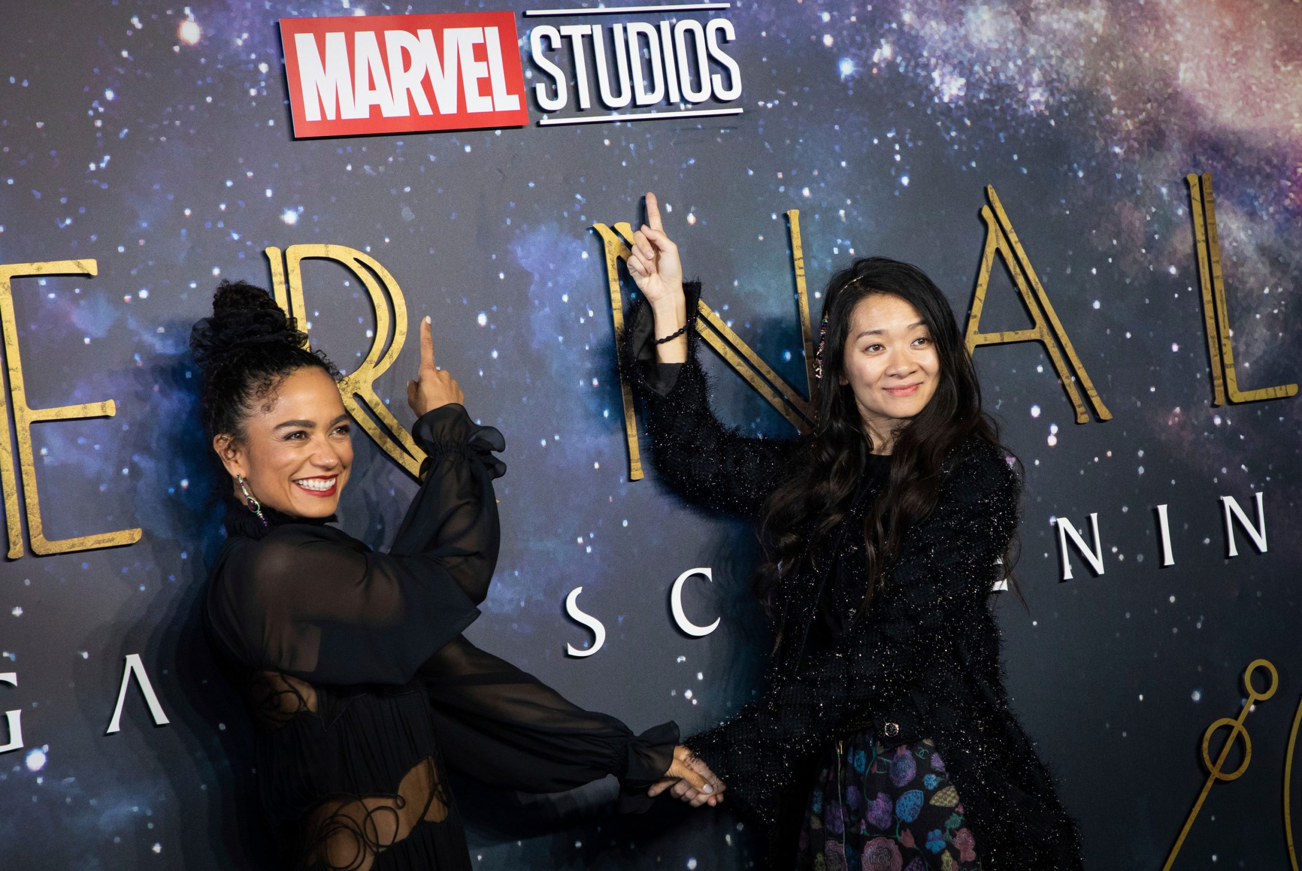 Lauren Ridloff and Chloe Zhao posing at an Eternals Poster