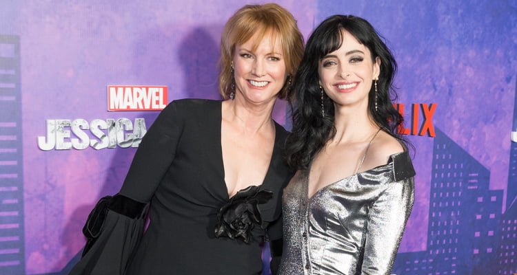 Melissa Rosenberg and Krysten Ritter posing in front of Jessica Jones billboard Riiter