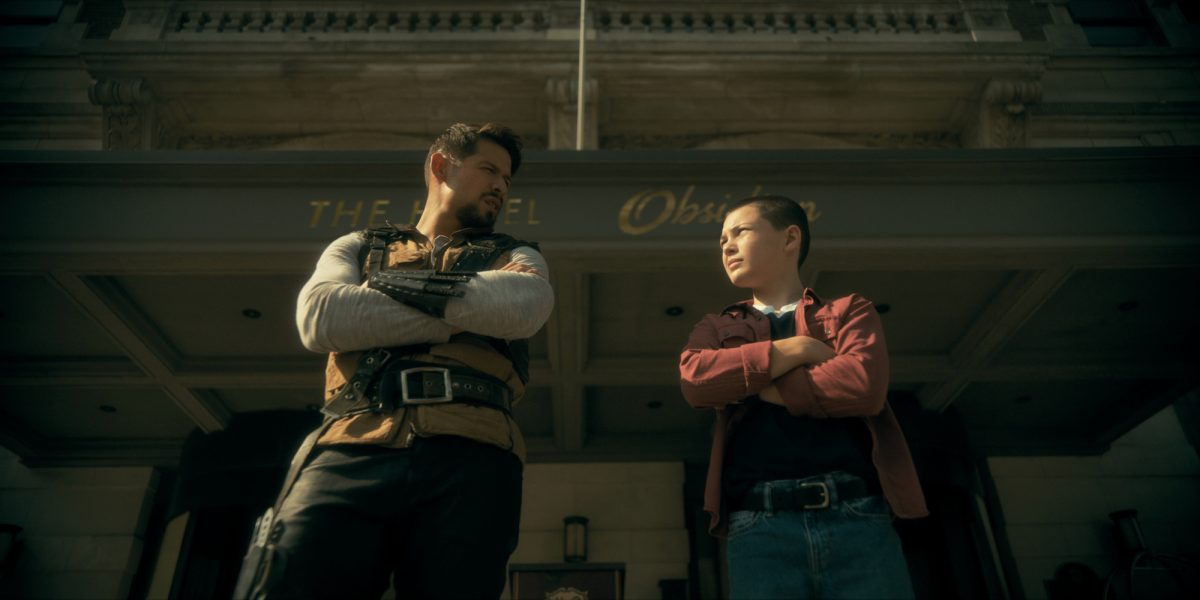 A still from Umbrella Academy season 3 of Diego and his son Stan standing with their arms crossed looking at each other