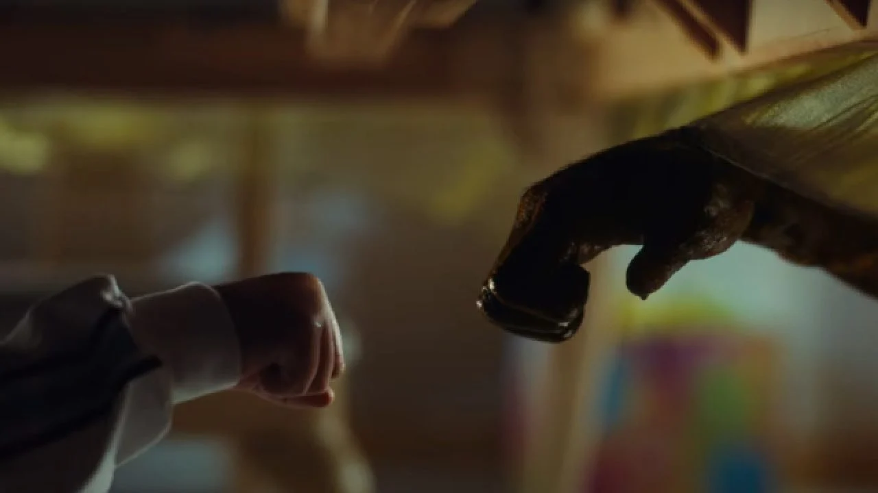 An image of a bloodstained chimp hand reaching out to fist bump June's small human hand