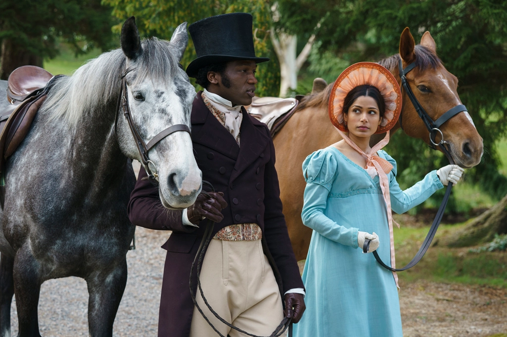 Mr. Malcolm dressed in a top hat and dark suit walks his horse on the left, and Selina dressed in a blue dress and pink bonnet walks her horse on the right