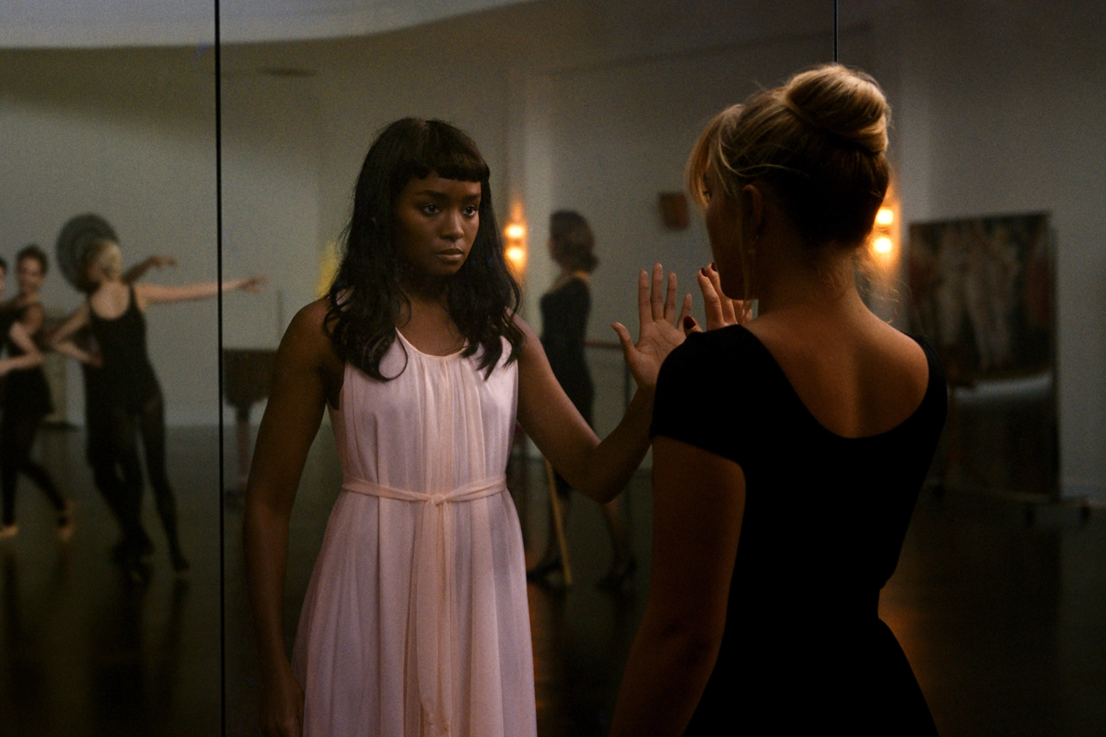 A still from Don't Worry Darling of Florence Pugh as Alice looking in a mirror, but her reflection is KiKi Layne as Margaret, who looks scared