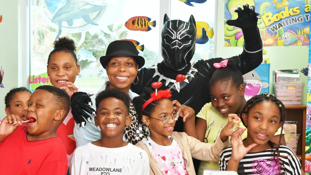 The Black Panther meets with Black children in an expression of joy.