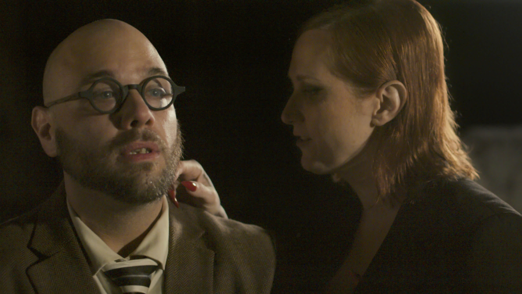 Michael Solace stares in fear as Monica touches his neck