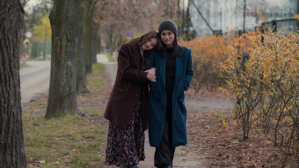 Meera and Geetika walking down a fall street