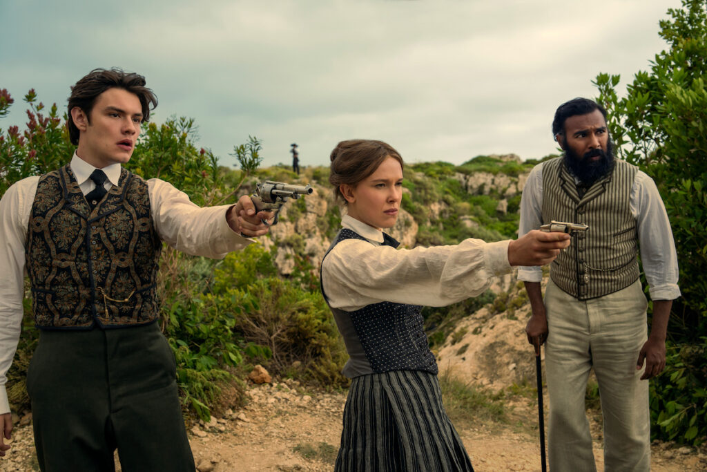 Enola Holmes (Millie Bobby Brown), Viscount Tewkesbury (Louis Partridge) and Dr. Watson (Himesh Patel)